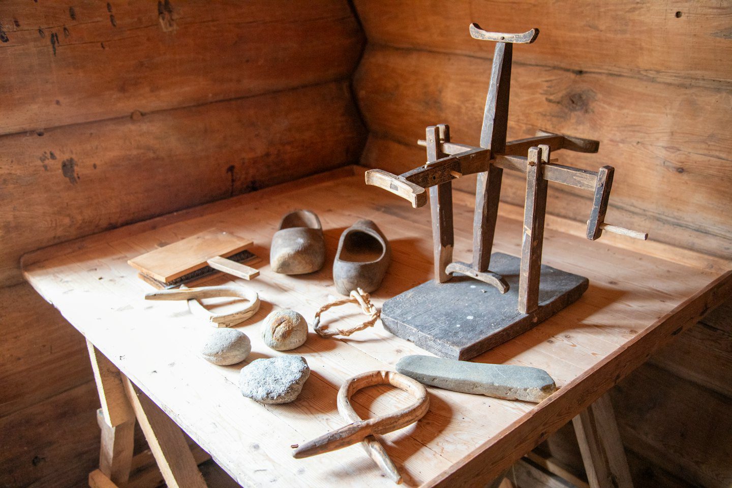 Handcrafted wooden items and stones on a cabin table.